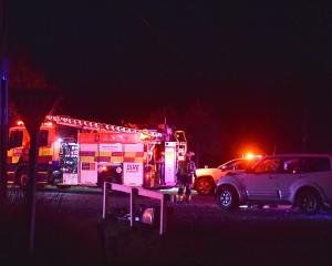 Emergency staff at the scene on Friday night. PHOTO: PETER MCINTOSH