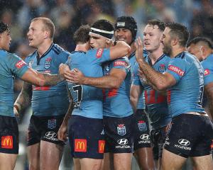 New South Wales' Nathan Cleary (C) celebrates with teammates after scoring a try against...