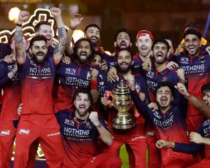 Jacob Duffy, behind Virat Kohli (with arms raised), and the Royal Challengers Bengaluru team...