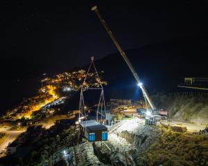 A home prebuilt in Christchurch is craned on to a steep Queenstown section at nighttime recently....