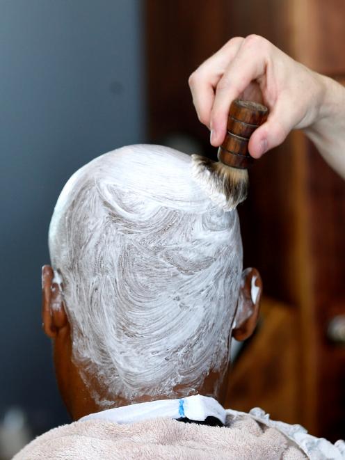 A client is prepared for shaving. Photo: Reuters 