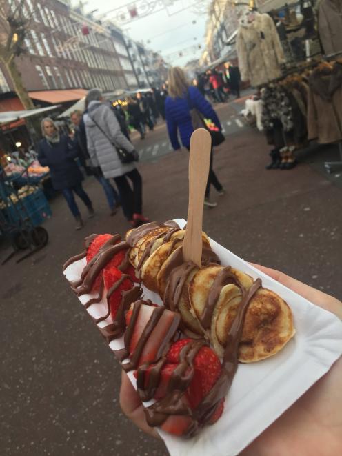 Poffertjes - mini Dutch pancakes - are served with Nutella and fresh strawberries at an Amsterdam...