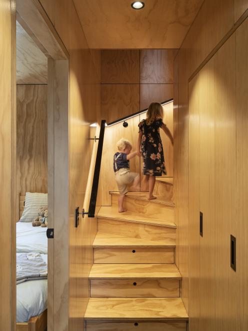 The built-in storage includes hidden cupboards and drawers within the steps of the stairs.