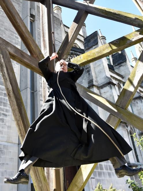 St Paul's Cathedral lay minister Bruce Aitken dangles from the church's bell as he welcomes home the first royal albatross to Taiaroa Head. Photo: Peter McIntosh