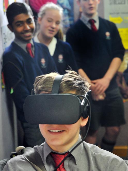 Kavanagh College pupil Alberto Adams (13) uses the CoDriVR driving simulator, while fellow pupils...