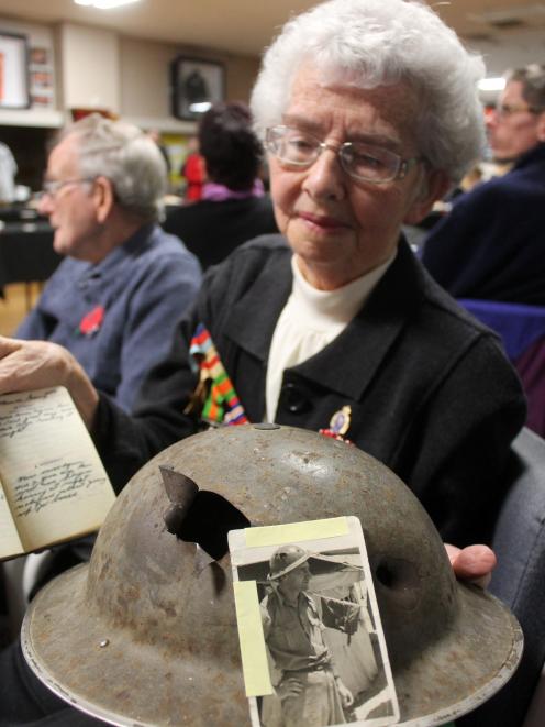 Carol Cosgrove, of Invercargill, holds the steel army helmet her father, George James Kennedy of...