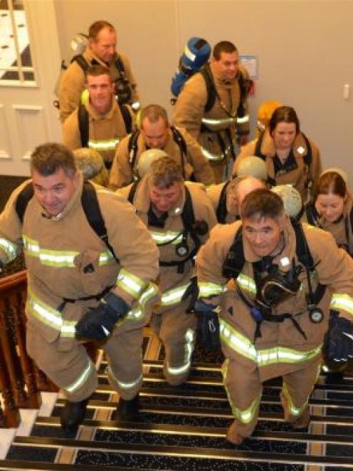 Cr Mike Lord (left), Dunedin Mayor Dave Cull and Cr Andrew Noone (behind) race up the stairs of the Municipal Chambers, followed by firefighters, yesterday. Photo by Stephen Jaquiery.