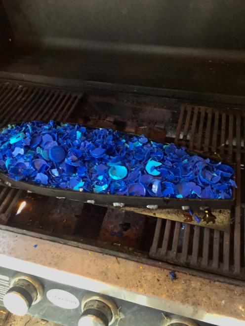 Neith shreds the bottle tops before melting them down in a steel mold on an old barbecue. Photo:...