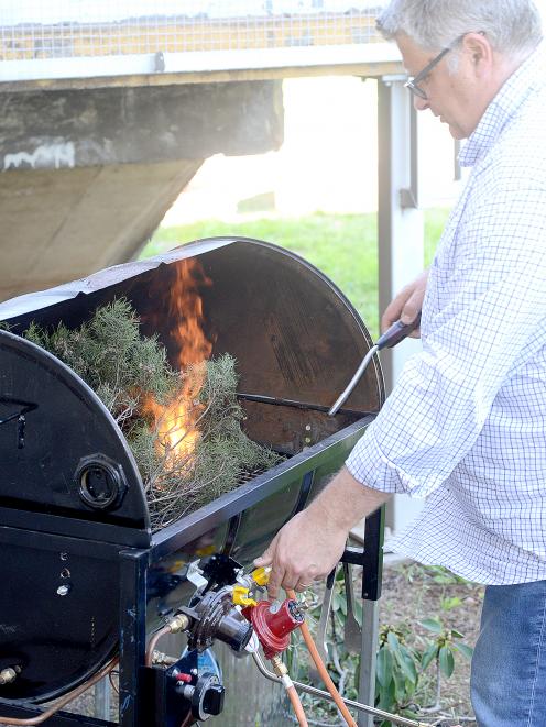 Tim Curran operating his plant barbecue. Photo: Jon Sullivan