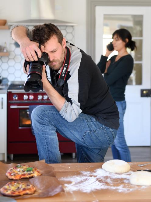 Carlos Bagrie photographs pizza for their lockdown book while Nadia Lim deals with a phone call...