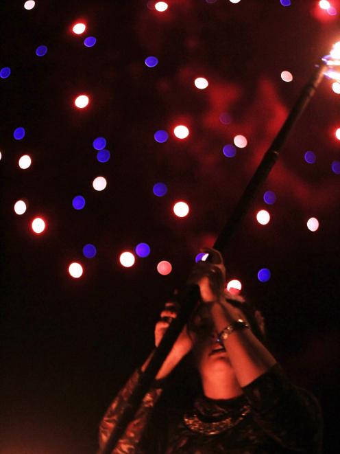 Shannon Wetdewich, of the Dunedin Fire and Circus Club, performs in Wansbeck St as fireworks...