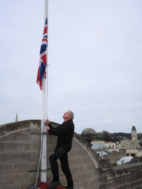Oamaru Whitestone Civic Trust chairman Graeme Clark lowers the Union Jack flag following the...