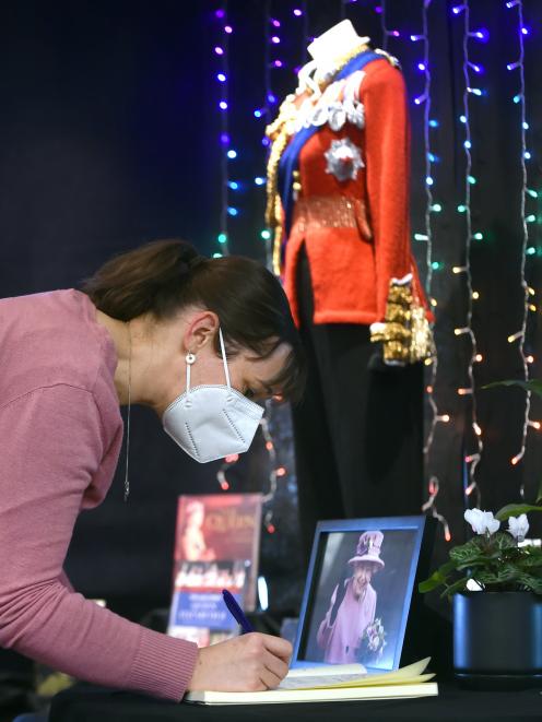 Angelina Martelli, of Dunedin, signs the condolences book at the Dunedin Public Library yesterday...