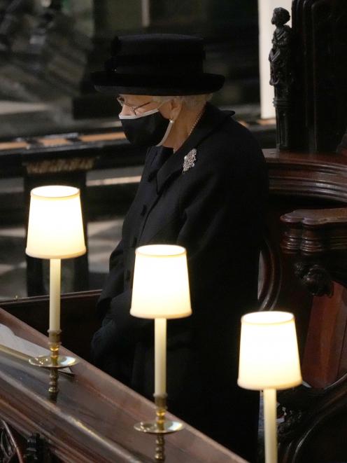 The Queen was forced to sit alone and wear a mask due to Covid-19 measures. Photo: Reuters 