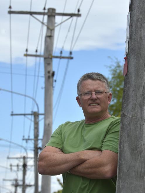 Geoff Lyell beside a red-tagged power pole in North Rd, Northeast Valley. Photo: Gerard O'Brien.
