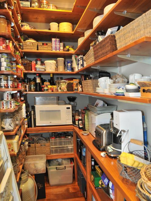 Macrocarpa shelving supports the well-stocked larder, just off the main living area.