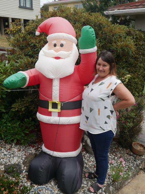 Helen Renault with the inflatable Santa in the front  yard of her Flower St property in Fairfield. PHOTO: JESSICA WILSON