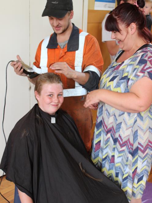 Nikita's brother Mitchell helps shave off her hair.