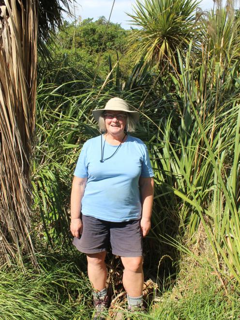 Gaileen Ross stands in front of native plants, trees and shrubs she planted at the Tomahawk...