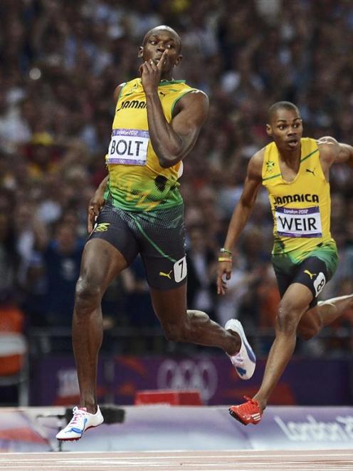 Jamaica's Usain Bolt celebrates as he crosses the finish line to win the men's 200m final. ...