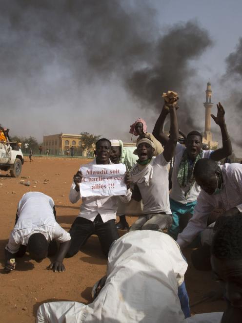 A man holds a sign during a protest against Niger President Issoufou's attendance last week at a...