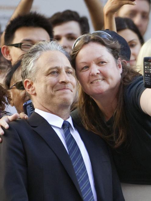 Jon Stewart poses with a fan as he arrives at the Toronto International Film Festival (TIFF) in...