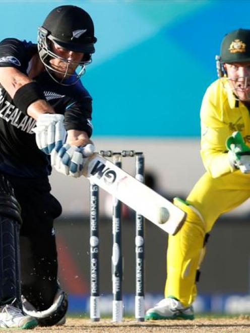 New Zealand's Corey Anderson hits out while being watched by Australia's Brad Haddin during their...