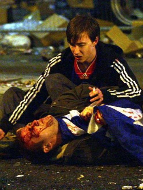 A Rangers fans lies hurt after clashes with riot police at Manchester's Piccadilly Gardens during...