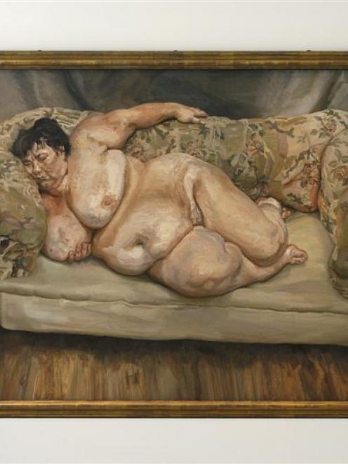 Employees hold Lucian Freud's painting 'Benefits Supervisor Sleeping' during a photo opportunity...