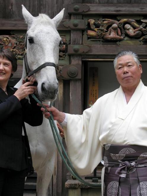 Prime Minister Helen Clark and Toshogu Shrine head priest Hisao Inaba stand with Kotuku, one of...