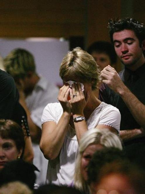 United in grief . . . Parents, teachers and pupils gather at Elim Christian College in Auckland...