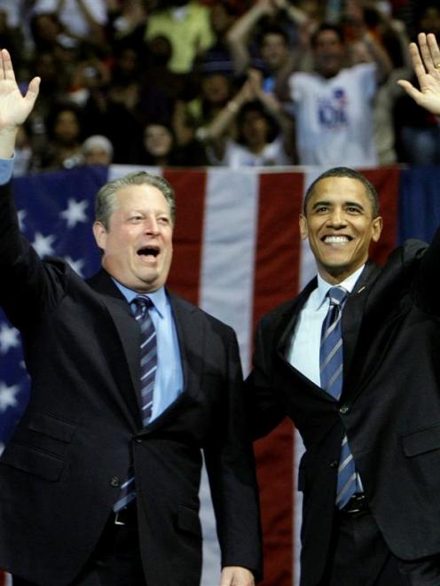 Democratic presidential candidate Barack Obama, right, waves to the crowd with former Vice...
