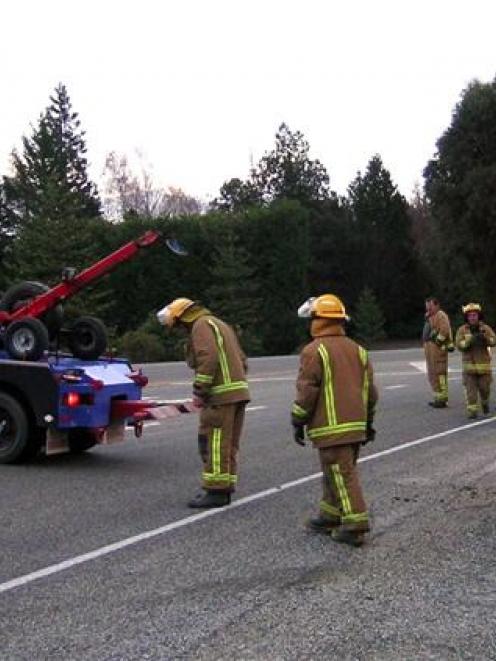 Emergency services workers right a four-wheel-drive vehicle which hit hit ice and flipped outside...