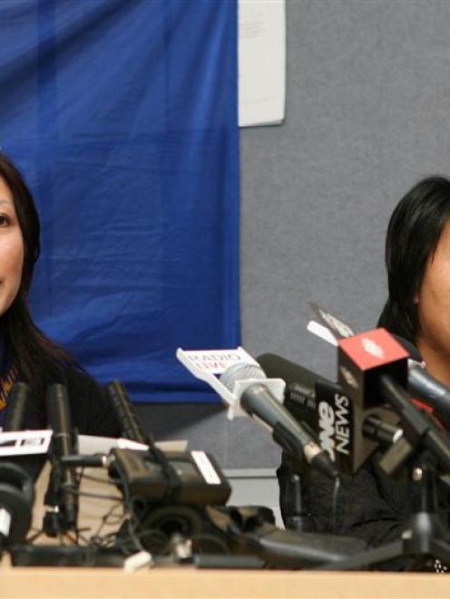 Hong Zhou, aunty of abducted 5-year-old Ma Xin Xin , left, speaks to the Media while Jin Zhou,...