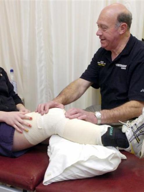 Medic Graeme Harvey treats Emma Beaven for a netball injury at the Sports Injury Clinic in the...