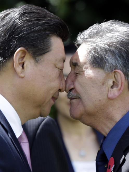 China's President Xi Jinping receives a hongi, a traditional Maori welcome, from Maori elder...