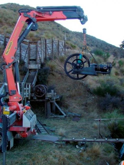 Contractor Charlie Skevington uses a hydraulic lifting arm to lower a 109-year-old Tangye stamper...