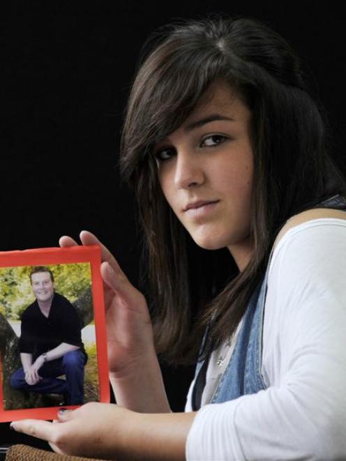 Melanoma awareness campaigner  Karli Adams (14)  holds a favourite photo of her father, Garth, ...