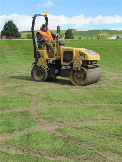 Nigel Harris, of Whitestone Contracting, tries to repair dozens of skid marks left by vandals on...