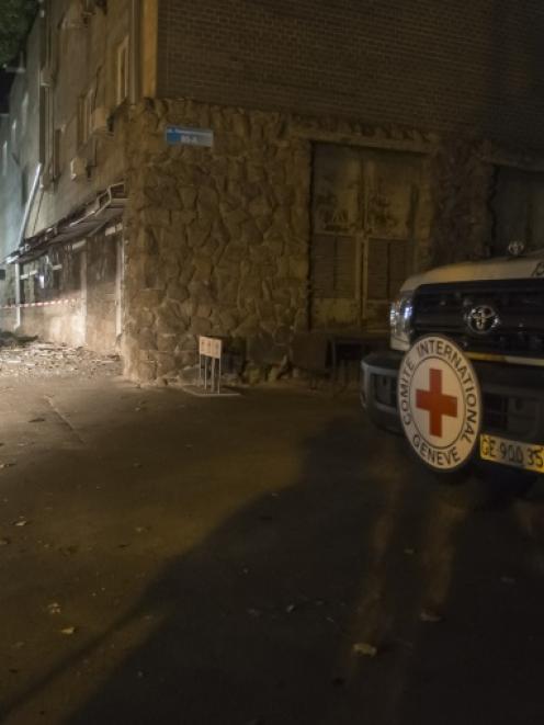 Red Cross vehicle is parked near the damaged office of the International Committee of the Red...
