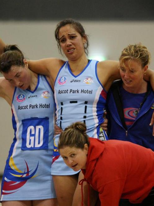 Southern Steel shooter Daneka Wipiiti is helped from the court by (from left) team-mate and...