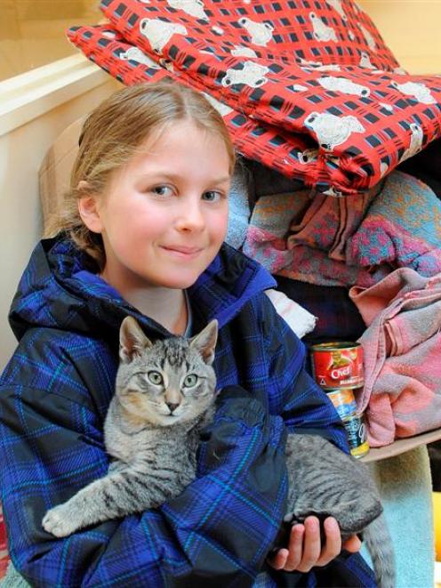 Wanaka Primary School pupil Neve Faed (8) cuddles a cat at the SPCA Otago  after donating boxes...