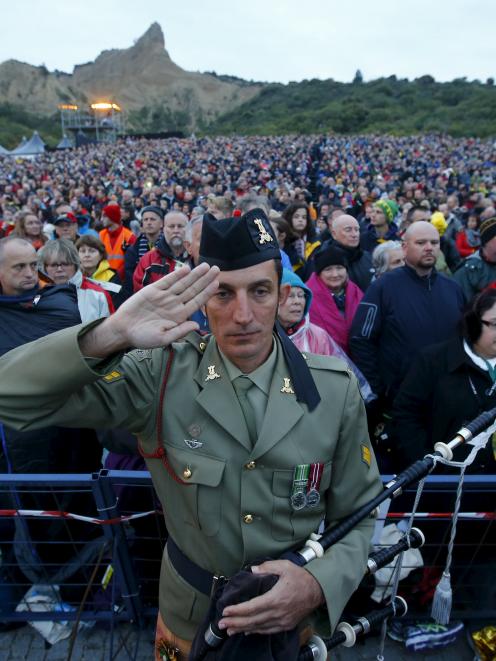 A bagpiper from the Australian army salutes during a dawn ceremony marking the 100th anniversary...