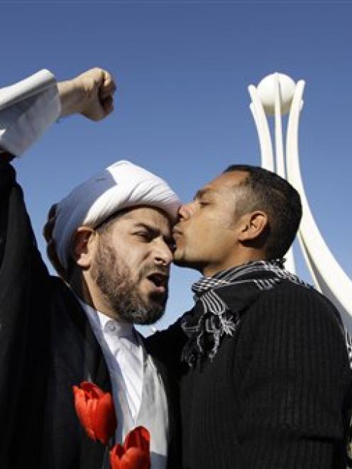 A Bahraini protesters kisses the head of Bahraini cleric at the Pearl roundabout soon after the...