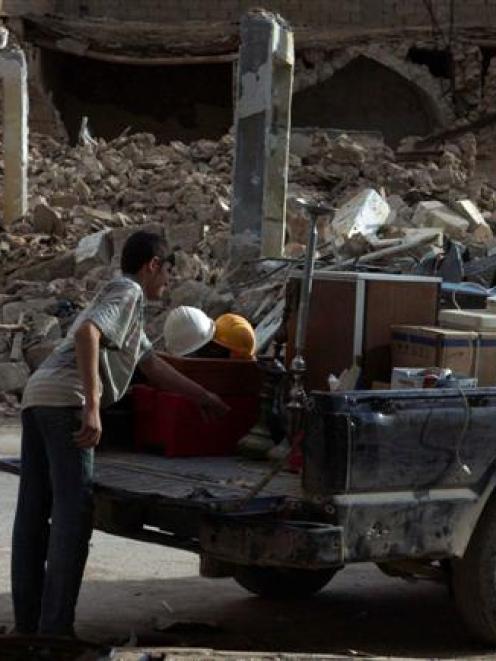 A boy loads a truck with the remains from his shop in Deir al-Zor after it was damaged by what...