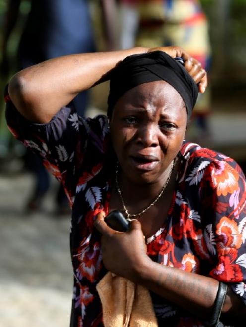 A bystander reacts as victims of the bomb blast arrive at the Asokoro General Hospital in Abuja....