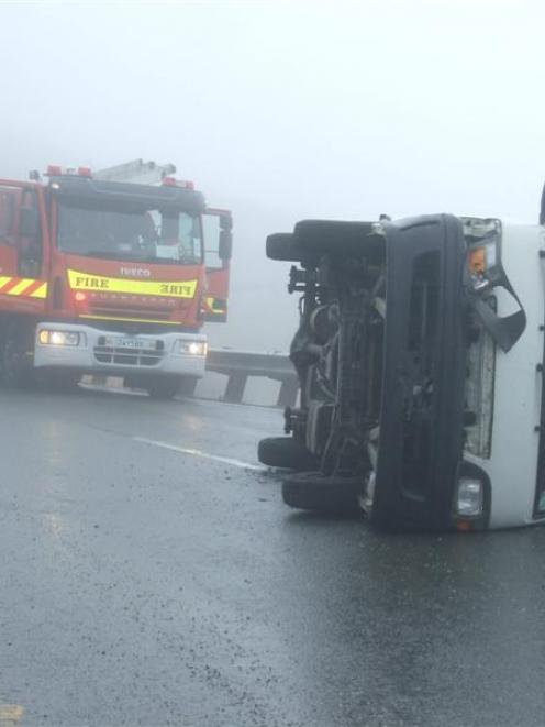 A  campervan  on its side blocks  a lane on the Crown Range Rd on Saturday. Photo by Christina...