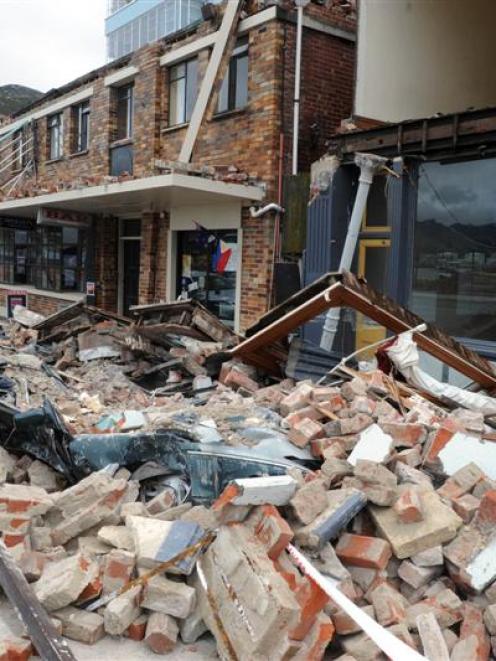 A car lies flattened by rubble fallen from a building beside the Lyttelton Hotel, in Lyttelton....