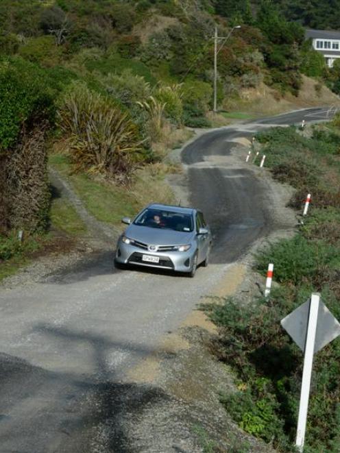 A car negotiates part of the road into Moeraki that has been reduced to a single lane after...