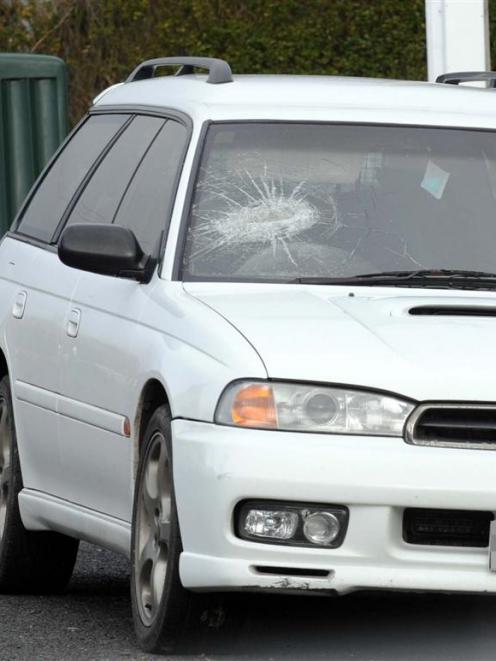 A car with a damaged windscreen sits outside the property. Photos by staff photographer.